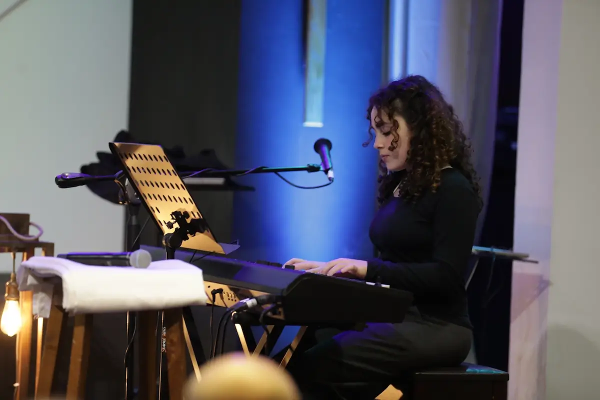 Student playing keyboard during a live worship session